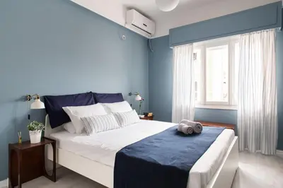 a bedroom with a large bed with blue walls at Stylish Syntagma apartment in Athens