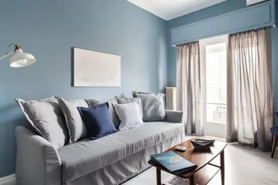 a living room with blue walls and a couch at Stylish Syntagma apartment in Athens
