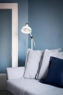 a blue room with a couch and a lamp at Stylish Syntagma apartment in Athens