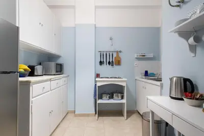 a kitchen with white cabinets and a counter top at Stylish Syntagma apartment in Athens