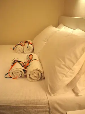 a white bed with towels and pillows on it at Cosy Flat Posh Quartier Kolonaki in Athens