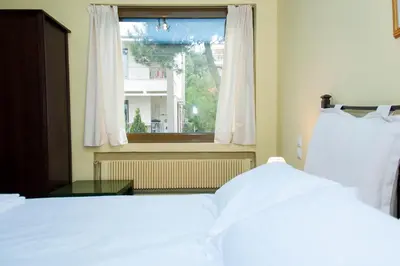 a bedroom with two beds and a window at Stephany Apartment in Athens
