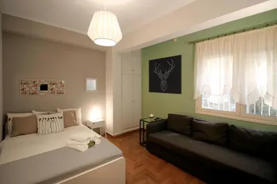 a living room with a bed and a couch at Luxury flat in Kolonaki, 3’ Metro in Athens