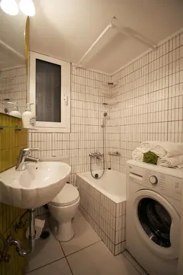 a bathroom with a sink toilet and a washing machine at Luxury flat in Kolonaki, 3’ Metro in Athens