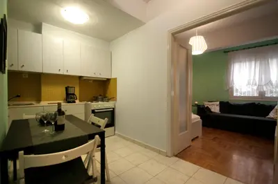 a kitchen and living room with a table and a couch at Luxury flat in Kolonaki, 3’ Metro in Athens