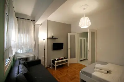 a living room with a couch and a tv and a table at Luxury flat in Kolonaki, 3’ Metro in Athens