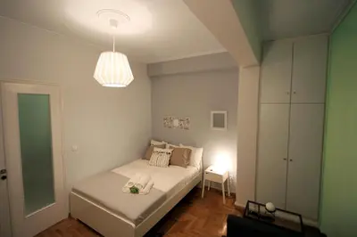 a small bedroom with a bed and a light at Luxury flat in Kolonaki, 3’ Metro in Athens