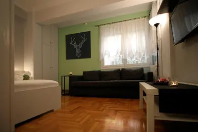 a living room with a couch and a window at Luxury flat in Kolonaki, 3’ Metro in Athens
