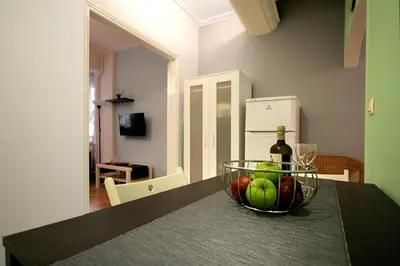 a bowl of fruit and a bottle of wine on a table at Luxury flat in Kolonaki, 3’ Metro in Athens