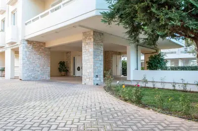 a large white building with a brick driveway at Krystal Apartment 