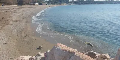 a beach with rocks in the sand and water at Krystal Apartment 