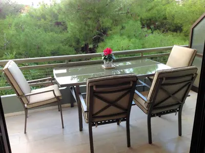 a glass table and chairs on a balcony at Amazing Apartment in Athens