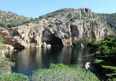 a river with a cave in the side of a mountain at Amazing Apartment in Athens