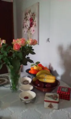 a table with a bowl of fruit and a vase of flowers at Lepa Kuca in Spáta