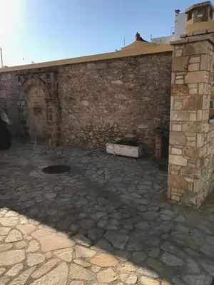 a building with a brick wall and a stone patio at Lepa Kuca in Spáta