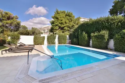 a swimming pool in a yard with bushes at Villa Noa in Anavissos