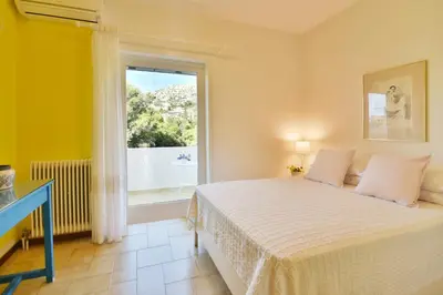 a bedroom with a bed and a large window at Villa Noa in Anavissos