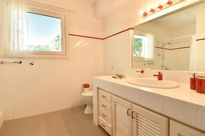 a bathroom with a sink and a toilet and a mirror at Villa Noa in Anavissos