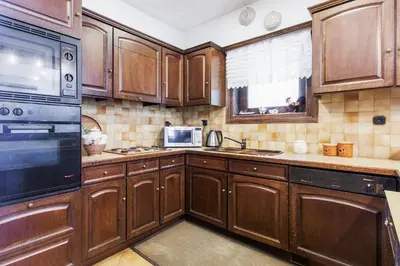 a kitchen with wooden cabinets and a microwave at Villa Noa in Anavissos