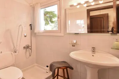 a white bathroom with a sink and a toilet at Villa Noa in Anavissos
