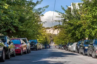 a row of cars parked on the side of a street at Acropolis Quiet Apartment in Athens
