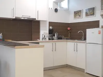 a kitchen with white cabinets and a white refrigerator at Acropolis Quiet Apartment in Athens