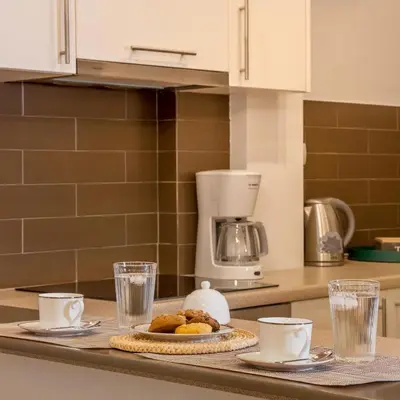 a kitchen counter with a plate of food and glasses at Acropolis Quiet Apartment in Athens