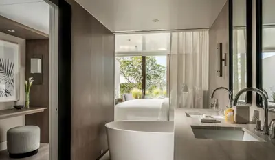 a bathroom with a tub and a bedroom with a bed at Four Seasons Astir Palace Hotel Athens in Athens