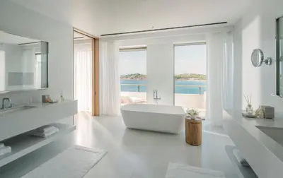 a white bathroom with a tub and a large window at Four Seasons Astir Palace Hotel Athens in Athens