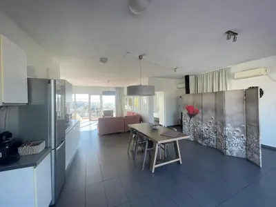 a kitchen and living room with a table and a refrigerator at Virgo - Loft with Spectacular View to Acropolis in Athens