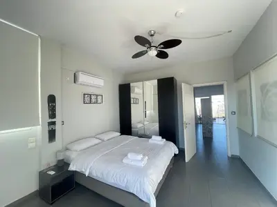 a bedroom with a bed and a ceiling fan at Virgo - Loft with Spectacular View to Acropolis in Athens