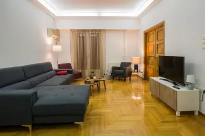 a living room with a couch and a tv at Capricorn - Luxurious apartment in Kolonaki in Athens