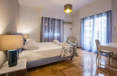a bedroom with a large bed and a table and chairs at Capricorn - Luxurious apartment in Kolonaki in Athens