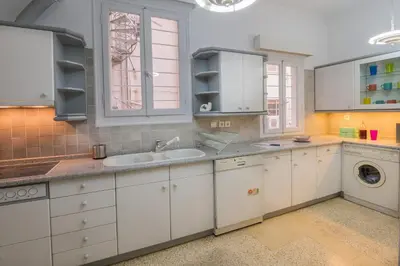 a kitchen with white cabinets and a sink at Capricorn - Luxurious apartment in Kolonaki in Athens