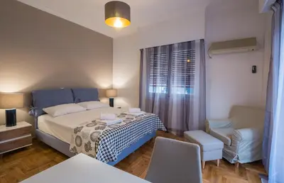a small bedroom with a bed and a chair at Capricorn - Luxurious apartment in Kolonaki in Athens