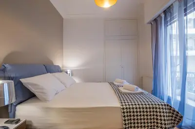 a bedroom with a large bed with a window at Capricorn - Luxurious apartment in Kolonaki in Athens