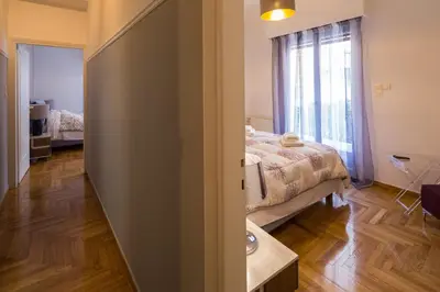a bedroom with a bed and a large window at Capricorn - Luxurious apartment in Kolonaki in Athens
