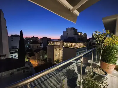 a view of a city at night from a balcony at Super Loft With Acropolis View in Athens