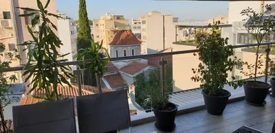 a balcony with potted plants and a view of a city at Super Loft With Acropolis View in Athens
