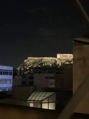 a building on top of a mountain in the background at Super Loft With Acropolis View in Athens