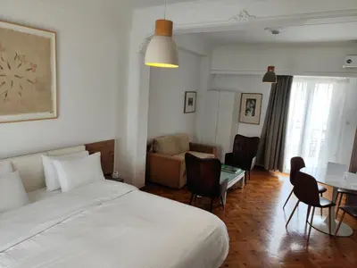 a bedroom with a bed and a table and chairs at Ulysses Apartments Acropolis in Athens