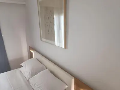 a white bed with a mirror on the wall at Ulysses Apartments Acropolis in Athens