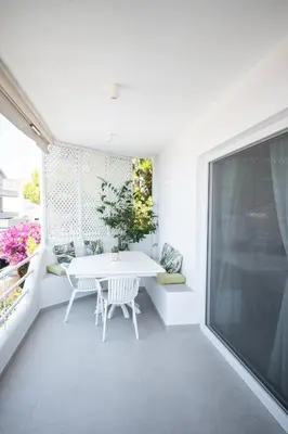 a white dining room with a table and a window at El Mar Seaview Penthouse 2 BDR, 7 min from beach in Lagonissi