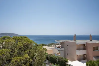 a building with the ocean in the background at El Mar Seaview Penthouse 2 BDR, 7 min from beach in Lagonissi