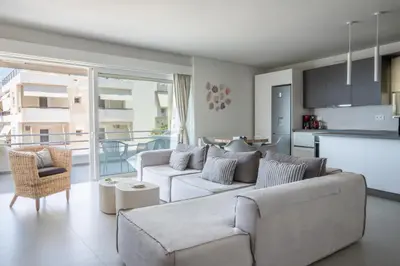 a living room with a couch and a kitchen at El Mar Seaview Penthouse 2 BDR, 7 min from beach in Lagonissi