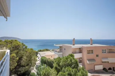 a view of a building with the ocean in the background at El Mar Seaview Penthouse 2 BDR, 7 min from beach in Lagonissi