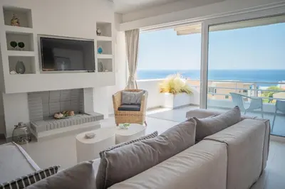 a living room with a couch and a large window at El Mar Seaview Penthouse 2 BDR, 7 min from beach in Lagonissi