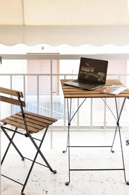 a laptop computer sitting on a desk next to a chair at Walk to Markets from a Cozy Studio by Cielo Homes in Athens
