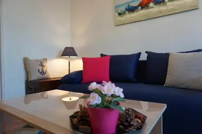 a living room with a blue couch and a table at Seaview apartment in Piraeus