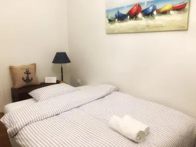 a bedroom with two beds and a painting on the wall at Seaview apartment in Piraeus